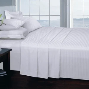 A white bedsheet double set neatly styled in a hotel/motel room for an aesthetic look