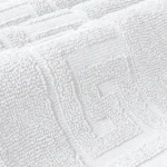 Elegant Greek Key border on a luxurious bath mat highlighting the industrial-grade stitching for spa and hotel use