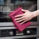 Using pink microfiber towel for cleaning glass surfaces