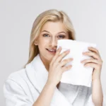 A guest using soft white washcloth with a premium feel required for upscale hospitality amenities