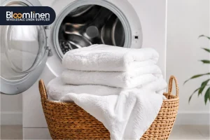 A stack of fresh, fluffy white hotel towels neatly folded on a surface